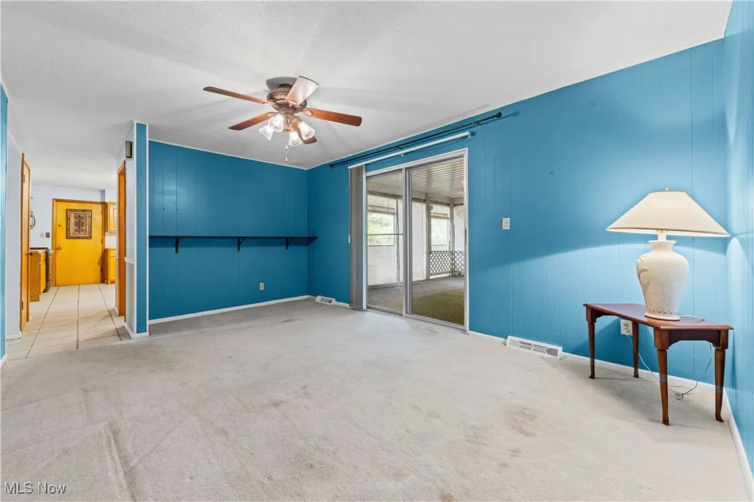 Family room featuring a ceiling fan and entrance to the covered porch.