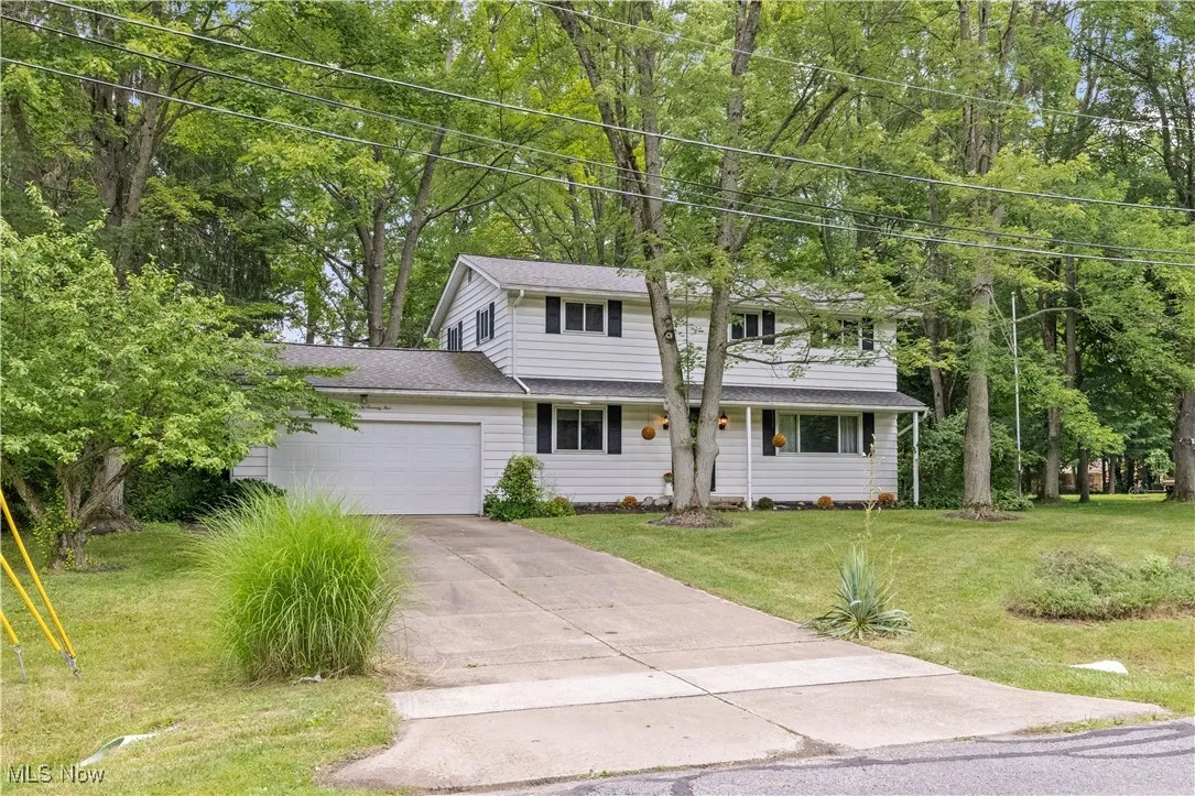 Traditional colonial style home w 2 car garage and a front lawn
