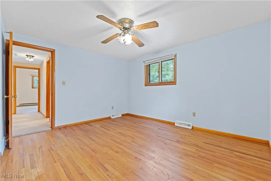Bedroom with light wood floors and ceiling fan