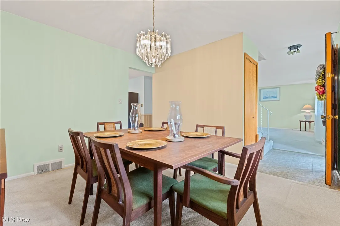 Dining room with light colored carpet built-in cabinet and dining room table to convey.