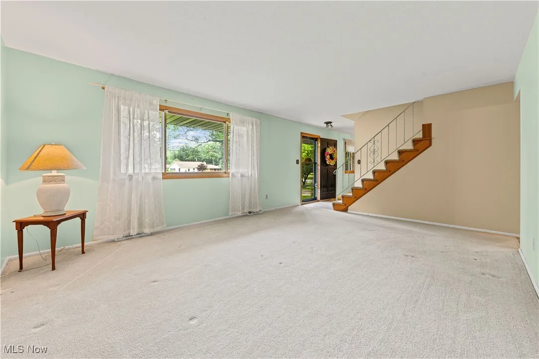 living room with stairs and large window