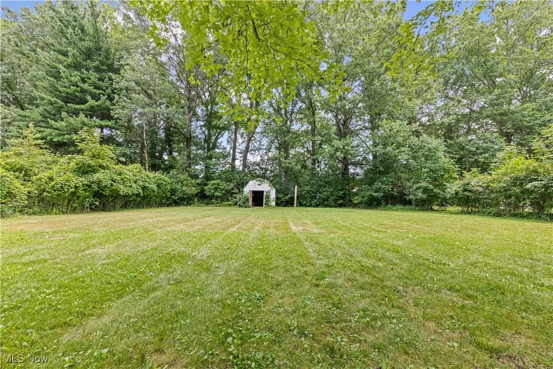 View of grassy yard featuring an outbuilding