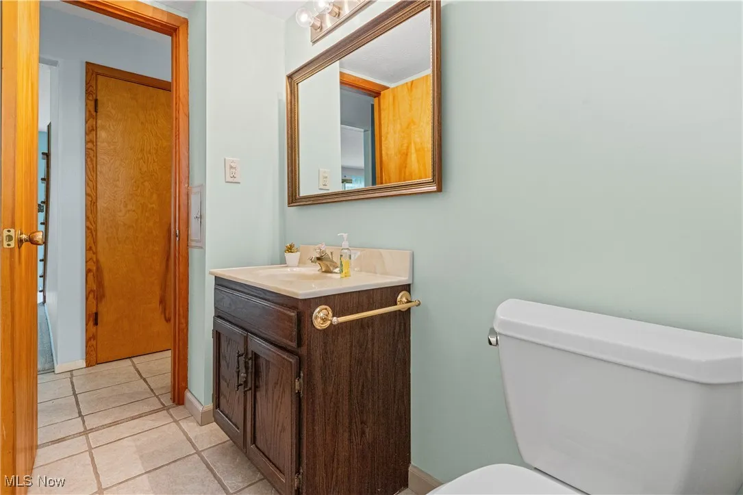Half bathroom featuring vanity and tile flooring