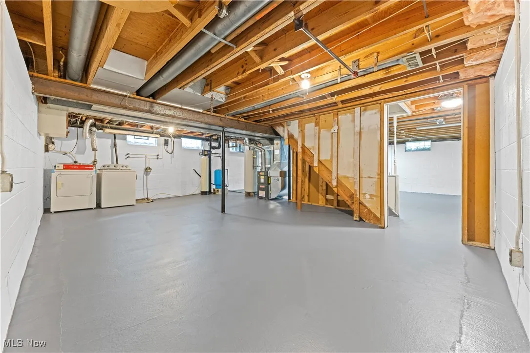 Below grade area featuring washer and  dryer, a water softener, stairway, and waterproofing