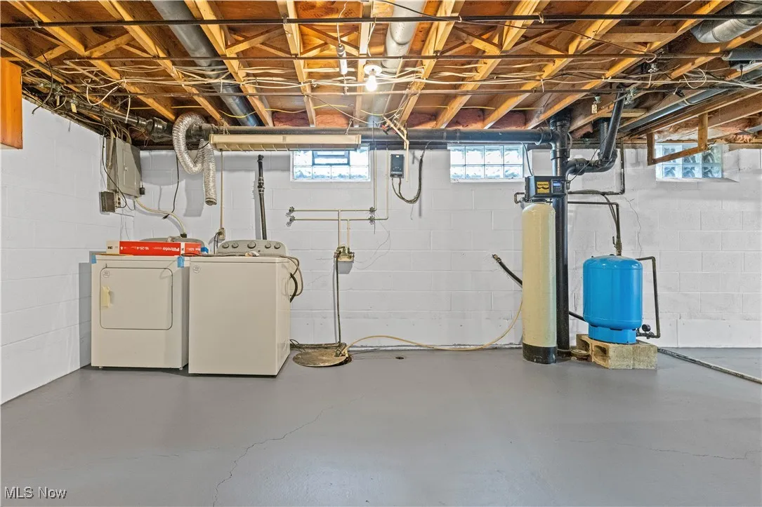 Basement featuring washer and dryer, and a water softener system