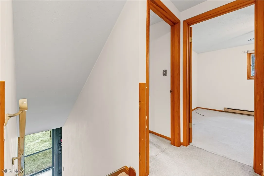 Upstairs hallway featuring carpet flooring and view into bedroom