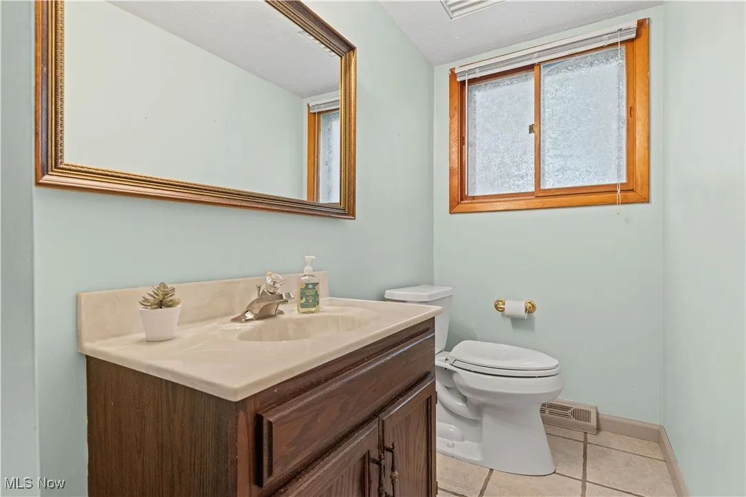 Half bathroom with vanity and tiled floors