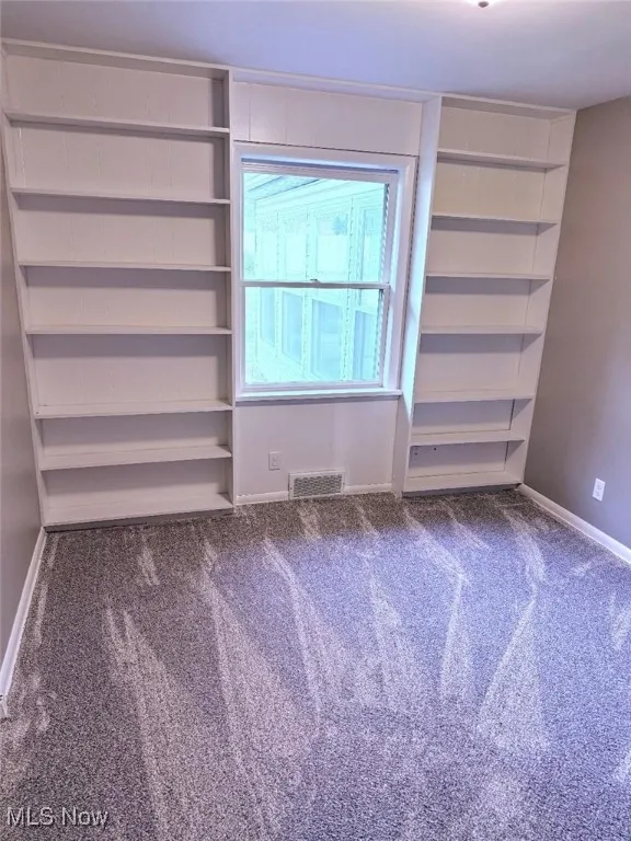 Carpeted empty room with baseboards