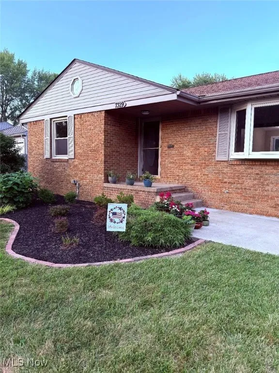 View of front of house featuring brick siding and a front lawn