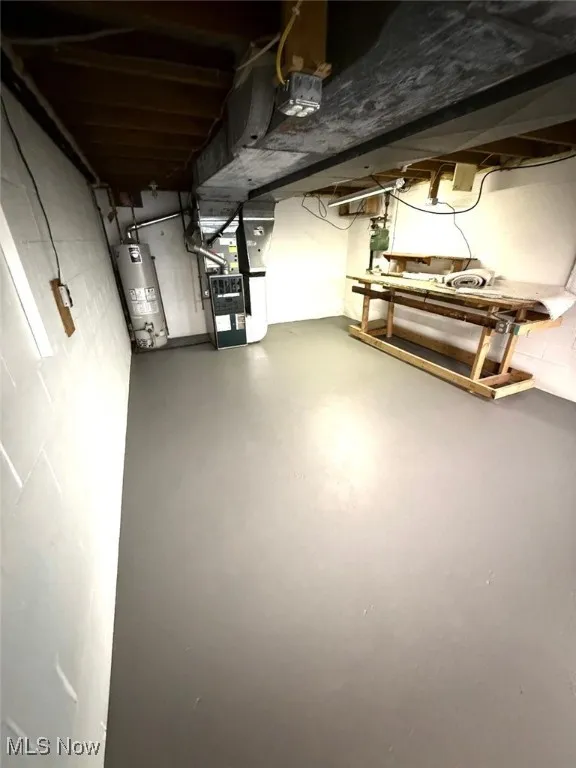 Unfinished below grade area with gas water heater and heating unit