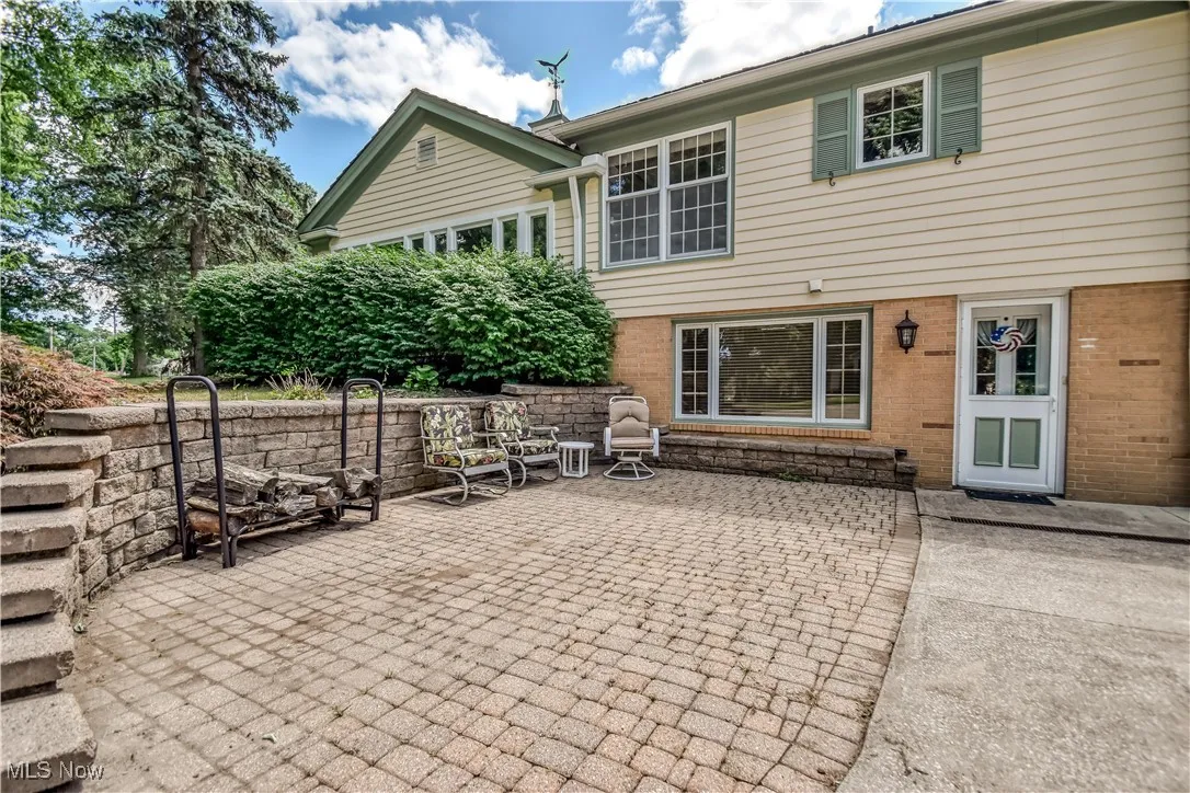Back of house featuring brick siding and a patio