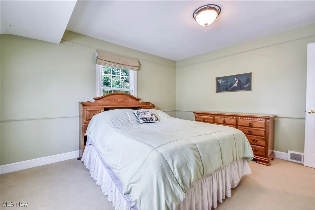 Bedroom with light carpet and baseboards