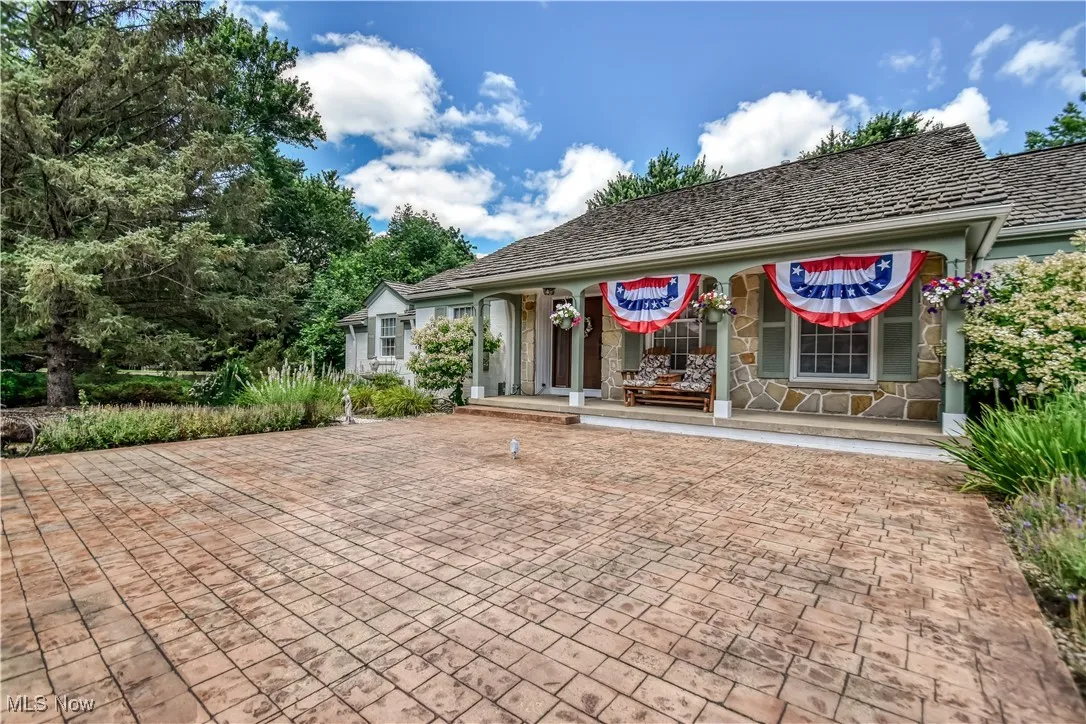 View of front of property featuring stone siding and a porch