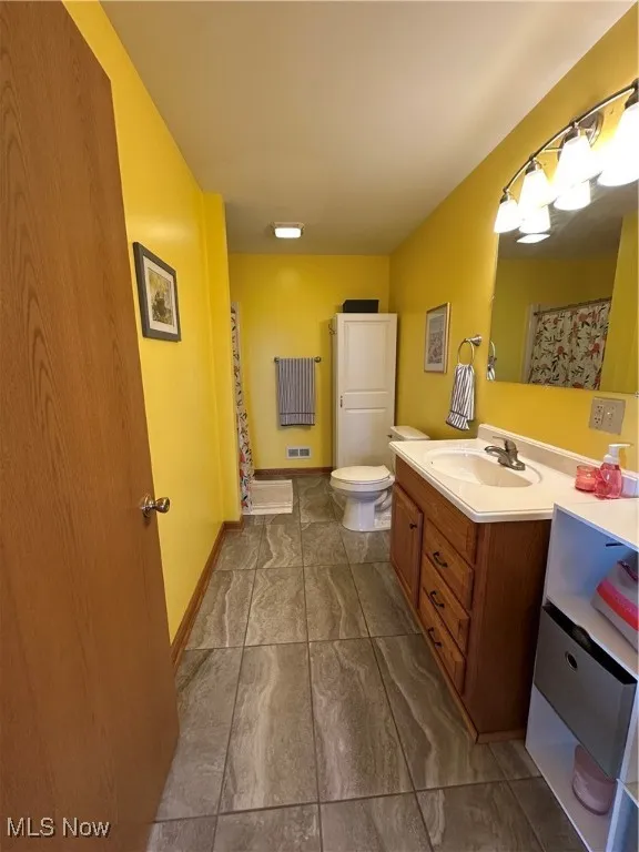 Full bathroom featuring vanity and toilet