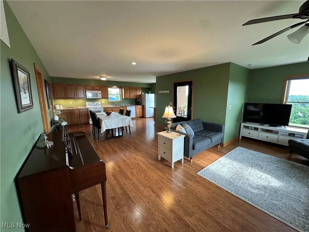 Living room with dark wood-style flooring, ceiling fan, and recessed lighting