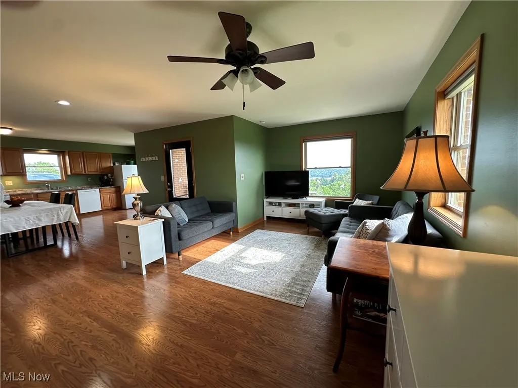 Living area with healthy amount of natural light, dark wood-type flooring, ceiling fan, and recessed lighting