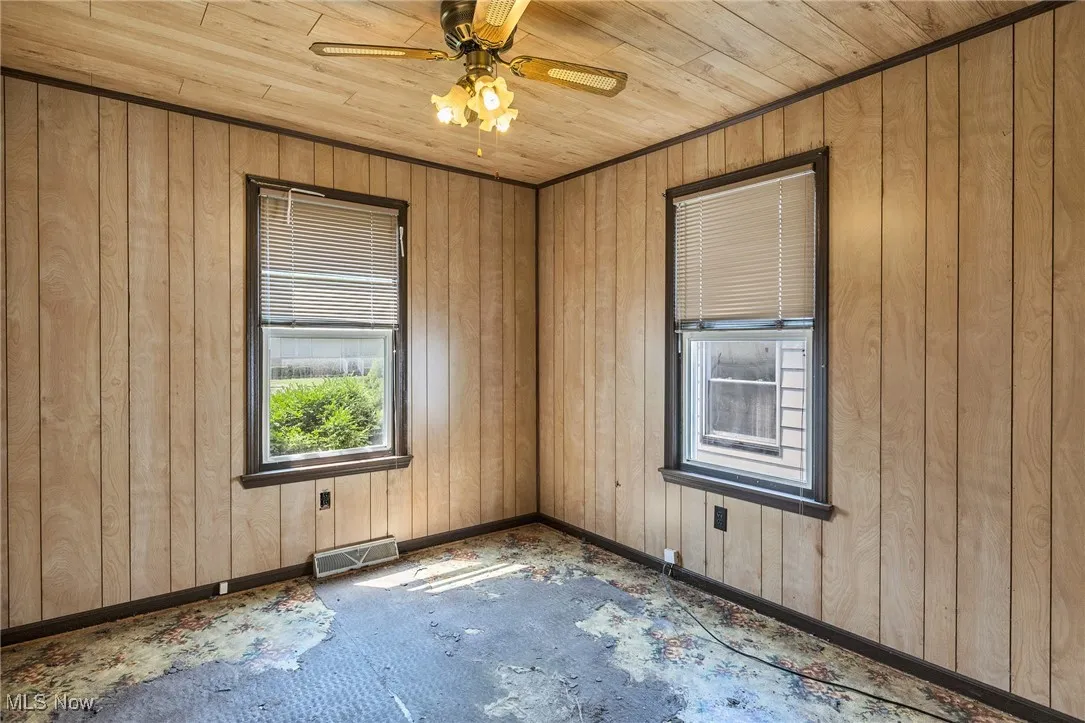 Spare room with wood walls, ceiling fan, and wood ceiling