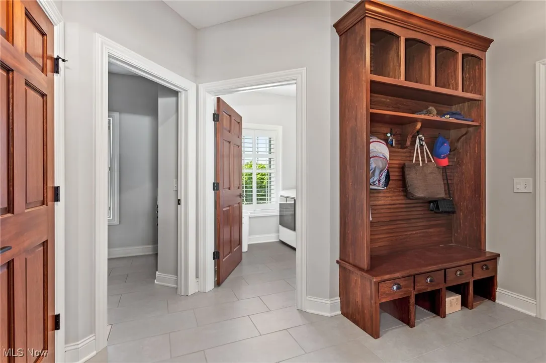 Mudroom with light tile patterned floors and baseboards