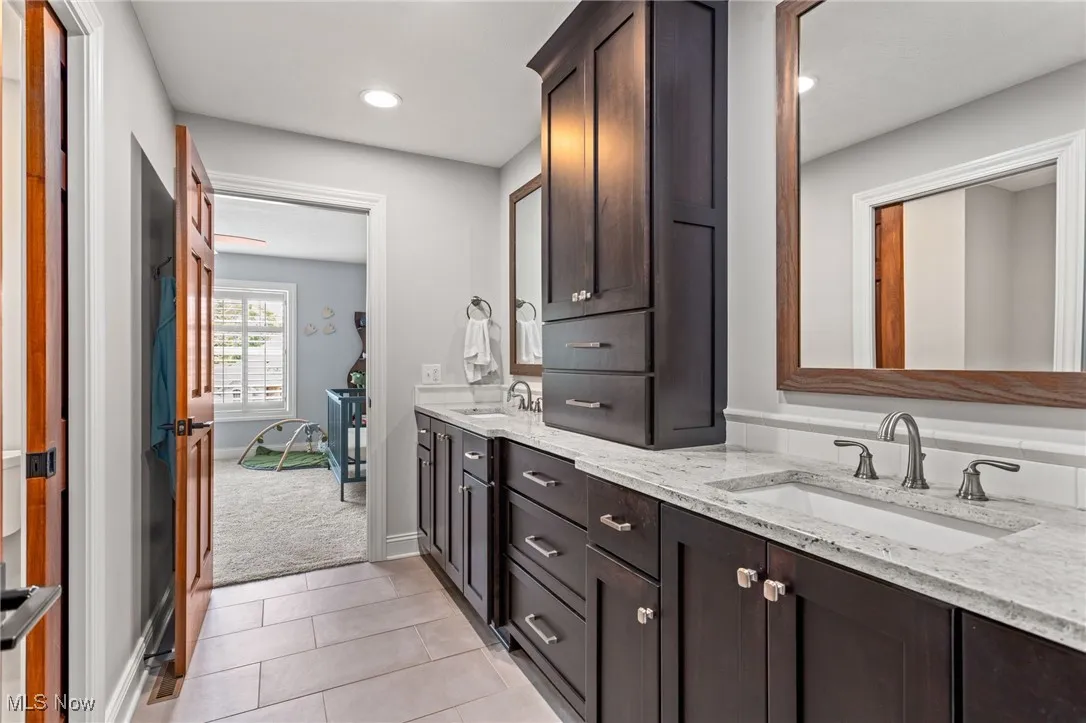 Bathroom with double vanity, tile patterned floors, and recessed lighting