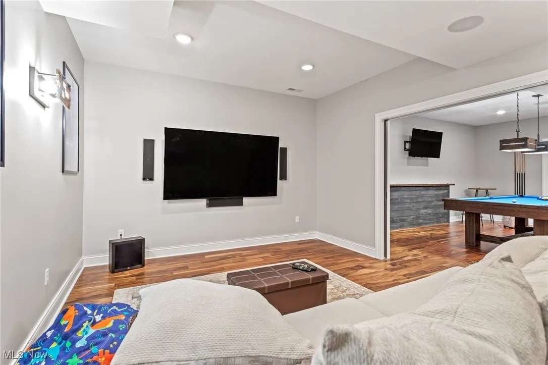 Living room with wood finished floors, billiards, and recessed lighting
