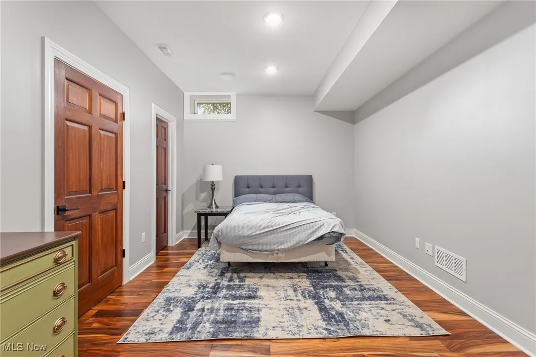 Bedroom with dark wood finished floors and recessed lighting