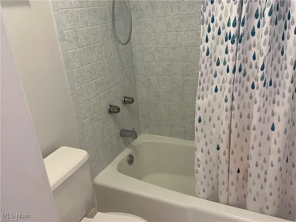 Bathroom with shower / bath combination with curtain