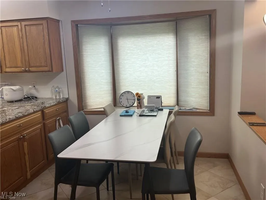 Dining space with baseboards and light tile patterned floors