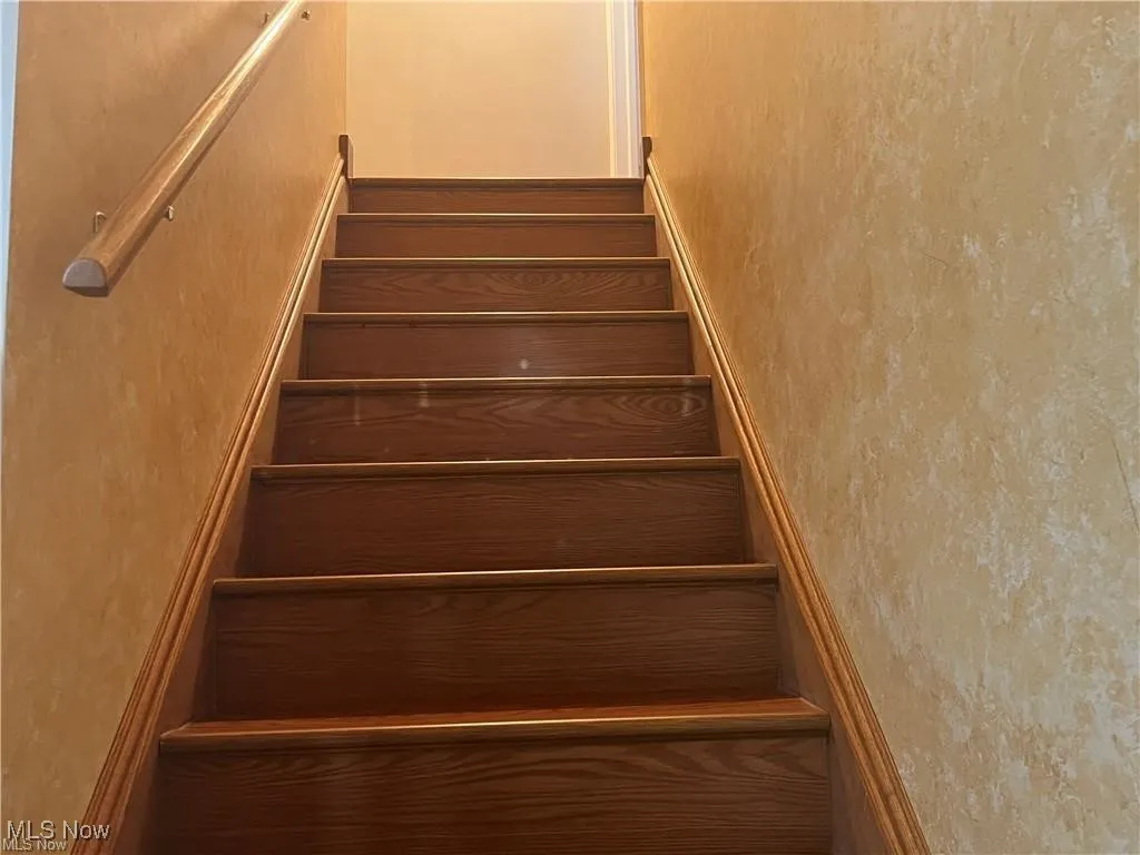 Staircase featuring a textured wall