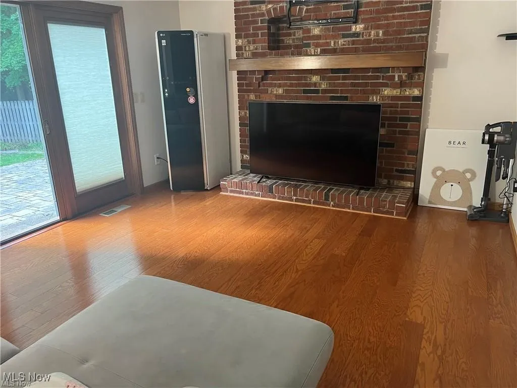 Living area featuring wood finished floors and a fireplace