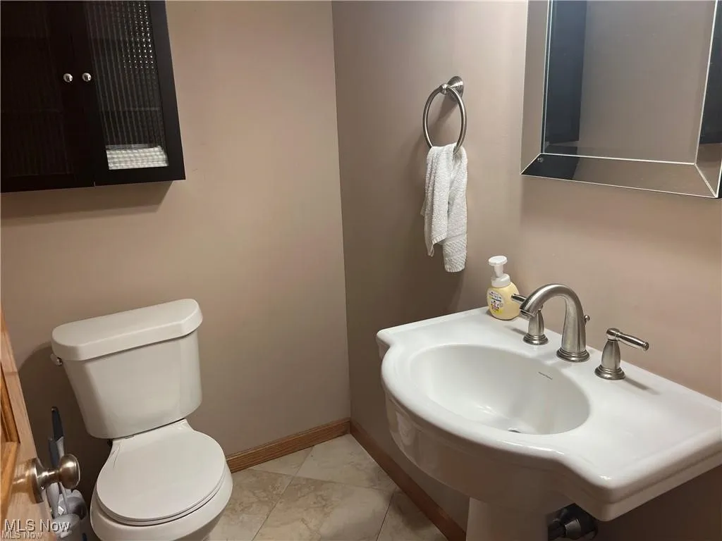 Bathroom with toilet and marble look tiles