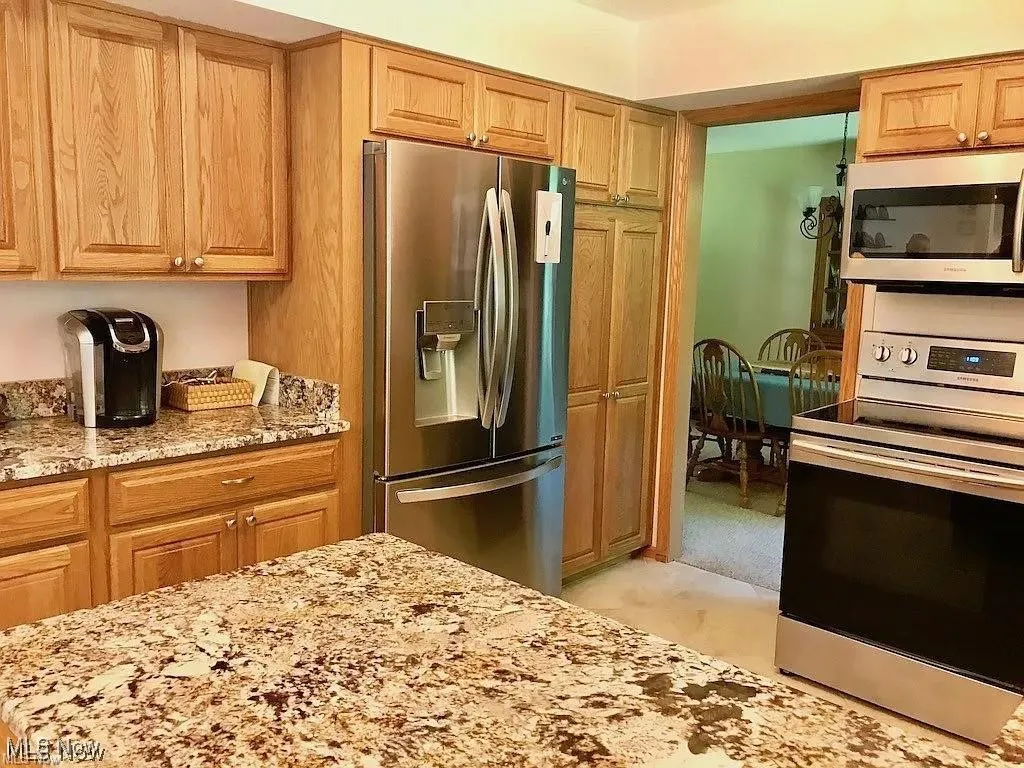 Kitchen with stainless steel appliances and light stone counters
