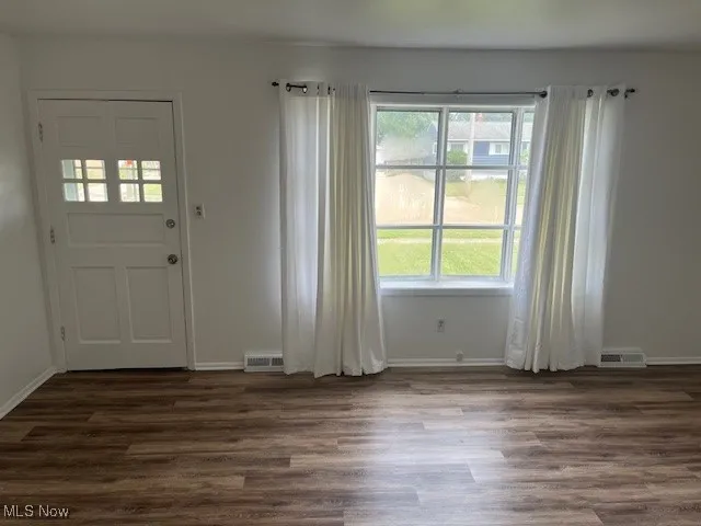 Entrance foyer with dark wood-type flooring and healthy amount of natural light