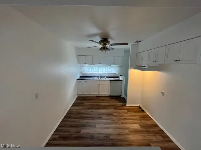 Kitchen with ceiling fan, white cabinetry, dark wood-style flooring, and white dishwasher