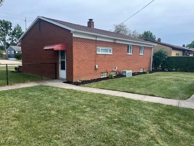 View of home's exterior with a chimney and brick siding