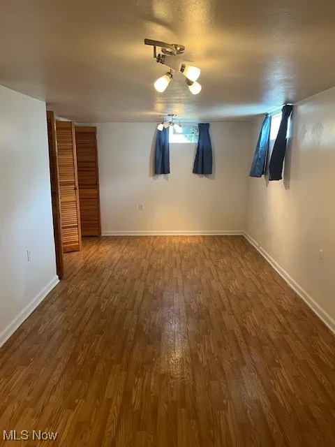 Unfurnished room with wood finished floors and baseboards