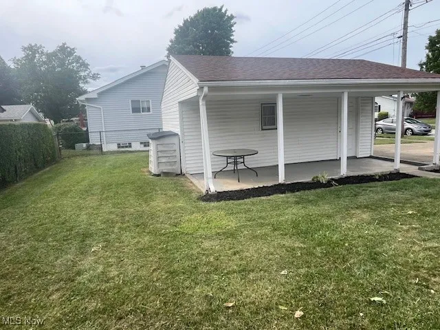 View of side of property with roof with shingles
