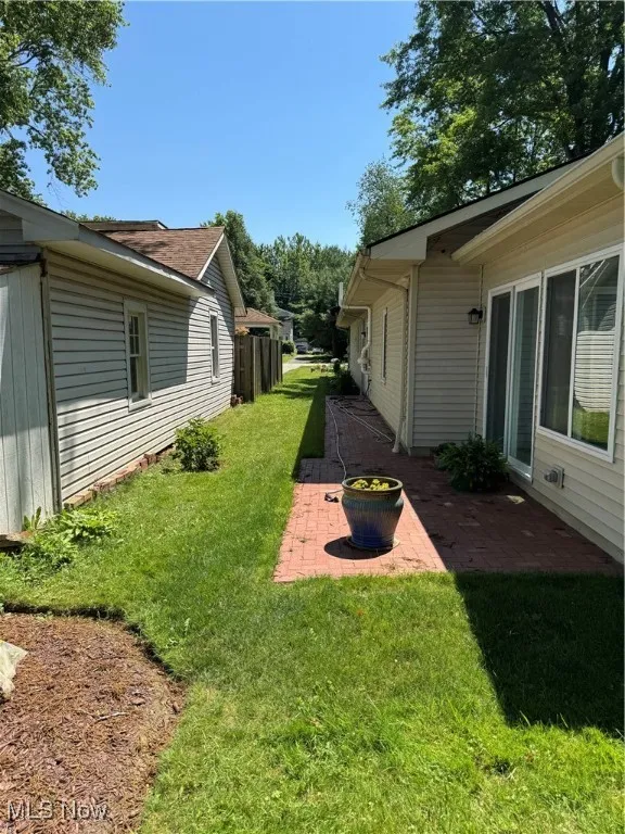 View of green lawn featuring a patio