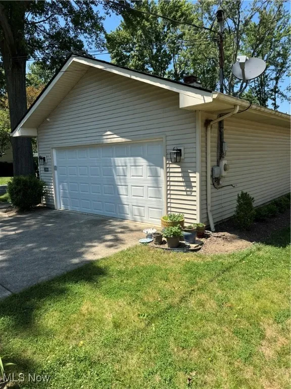 View of side of home featuring an outbuilding and a yard