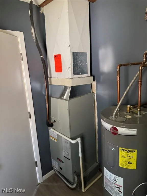 Utility room featuring water heater and heating unit