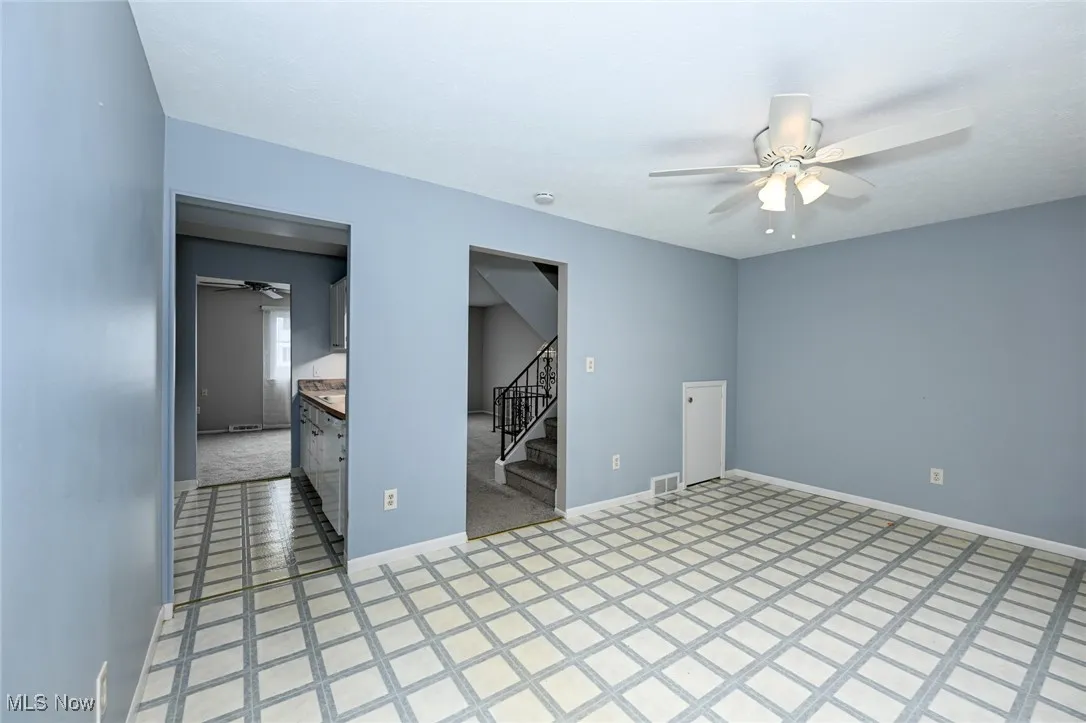 Spare room with ceiling fan and stairway