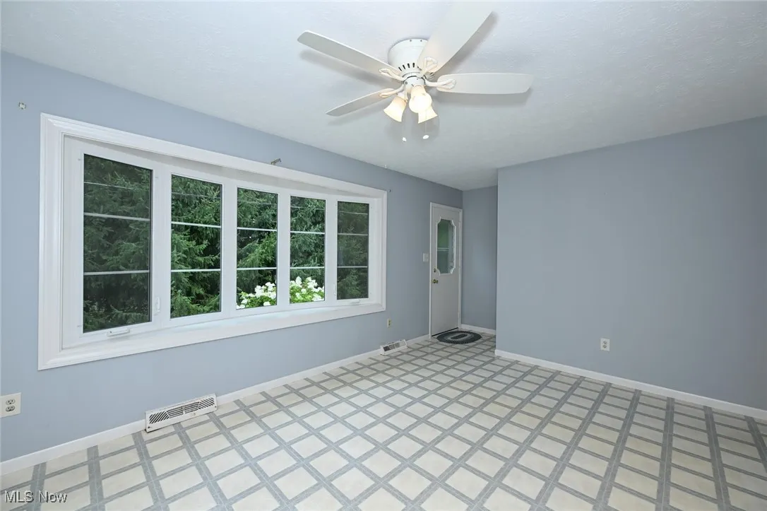 Unfurnished room with a ceiling fan and light flooring