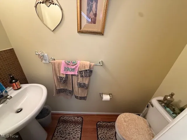 Bathroom with toilet and wood finished floors