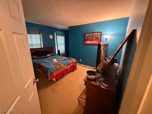 Bedroom with carpet floors and a textured ceiling