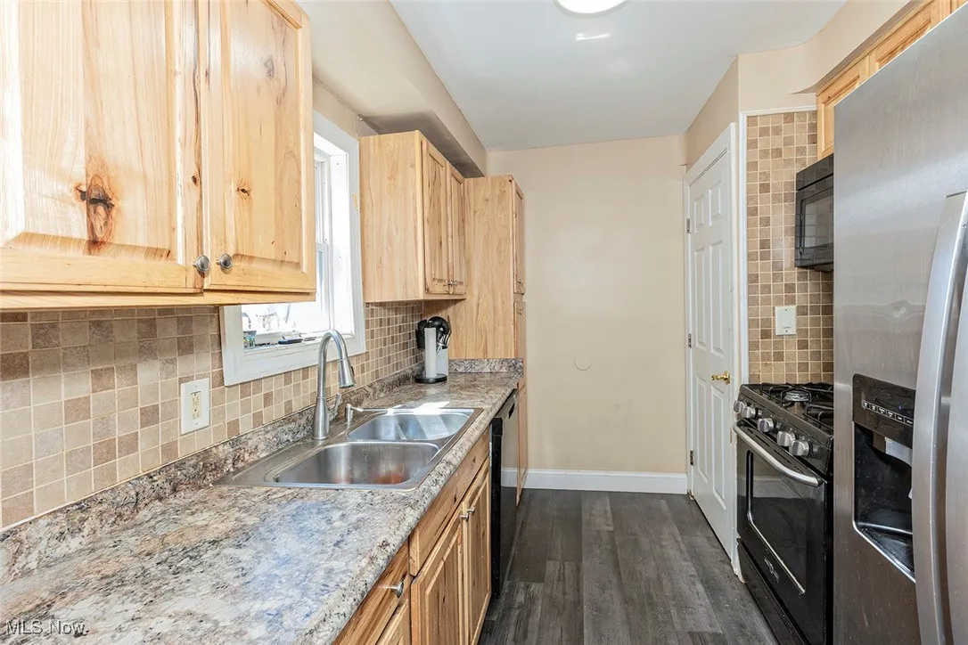 Tile backsplash and newer hickory cabinets are featured in the kitchen