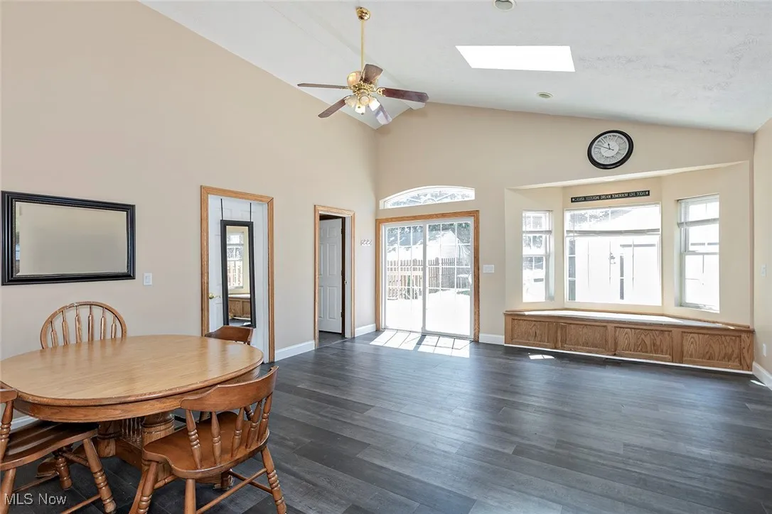 Family Room is highlighted by skylights set into a vaulted ceiling, and a bay window with window seat. There is a set of sliding glass doors enhanced by a decorative eyebrow window above the sliders. Sliding doors lead to deck.