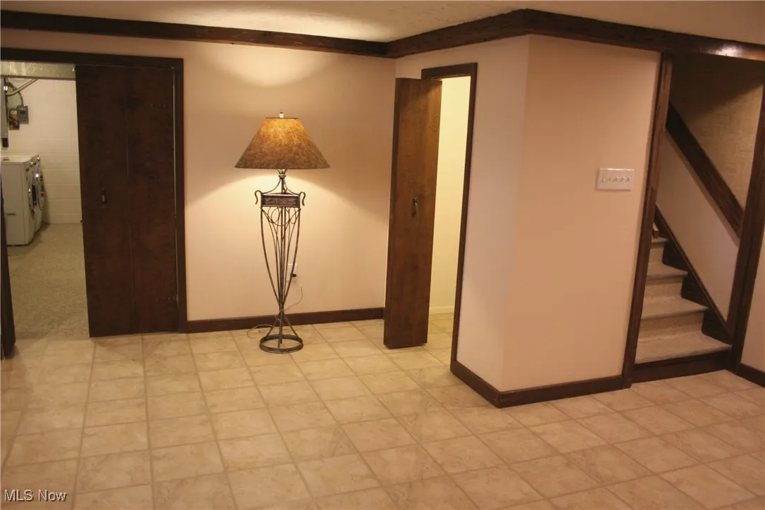 Unfurnished room featuring washing machine and clothes dryer and stairs
