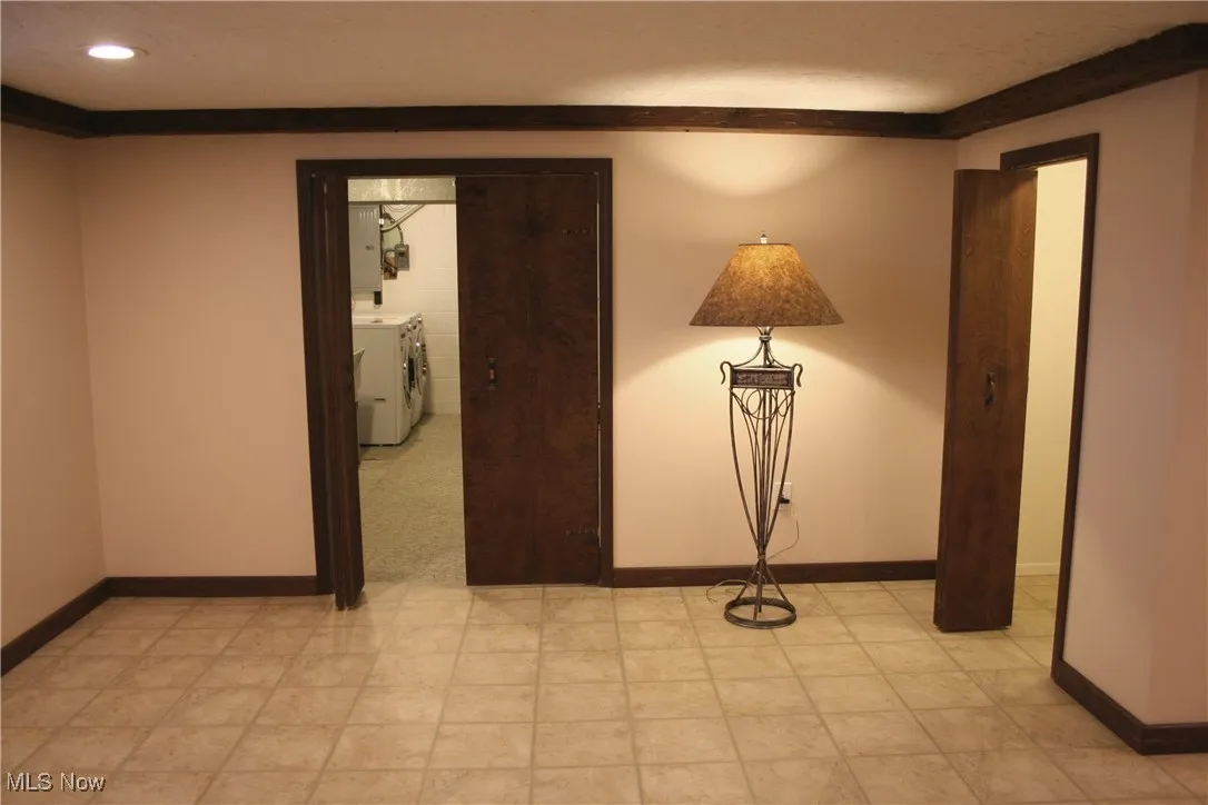 Unfurnished room featuring washing machine and clothes dryer and baseboards