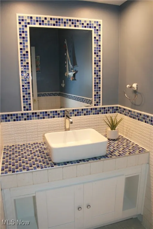 Bathroom with vanity and tile walls