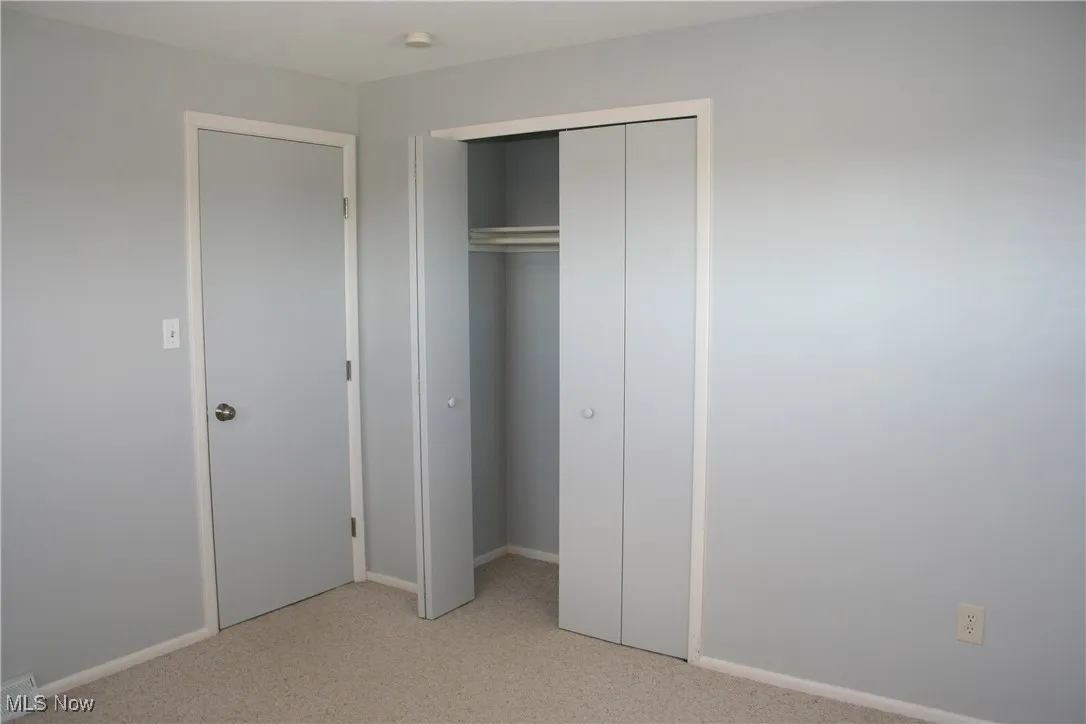Unfurnished bedroom featuring light colored carpet and a closet