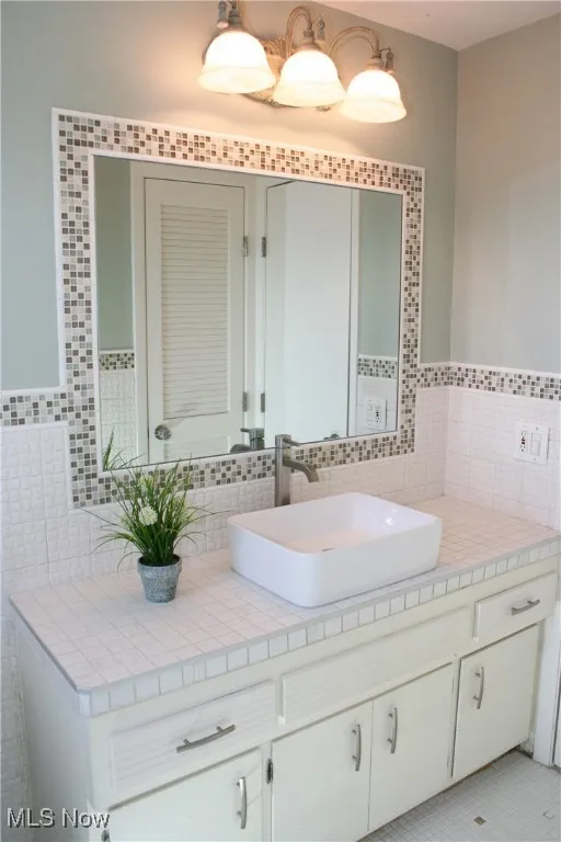 Bathroom featuring vanity and backsplash